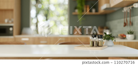 Spices bottles and a copy space on a dining table in a modern green and wood kitchen. 110270716