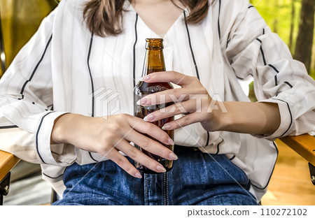 年輕女子露營時一手拿著啤酒放鬆的豪華露營圖片 110272102