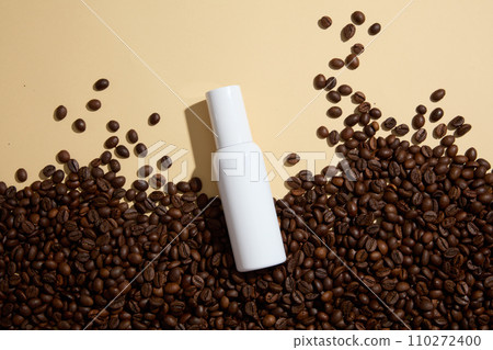 Blank background for advertising cosmetic product with coffee ingredient. Coffee beans decorated with white cosmetic bottle without label for design packaging. Top view Blank background for advertising cosmetic product with coffee ingredient. Coffee beans decorated with white cosmetic bottle without label for design packaging. Top view 110272400