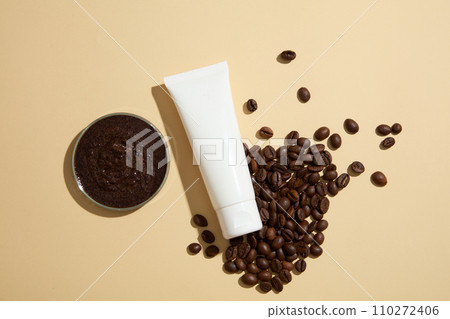 Mockup plastic tube of cosmetic displayed on beige background with coffee beans and petri dish filled with coffee grounds. Top view, concept for advertising organic cosmetics. Space for design Mockup plastic tube of cosmetic displayed on beige background with coffee beans and petri dish filled with coffee grounds. Top view, concept for advertising organic cosmetics. Space for design 110272406