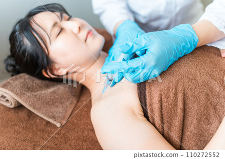 一名婦女和一名醫生對肩部進行肉毒桿菌/塊注射(肩膀僵硬) 一名婦女和一名醫生對肩部進行肉毒桿菌/塊注射(肩膀僵硬) 110272552