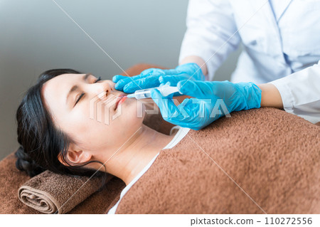 Gummy smile treatment: patient and cosmetic surgery doctor injecting Botox, hyaluronic acid, and fat-dissolving injections under the nose and upper lip Gummy smile treatment: patient and cosmetic surgery doctor injecting Botox, hyaluronic acid, and fat-dissolving injections under the nose and upper lip 110272556