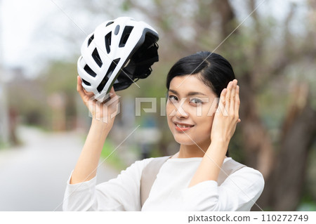 Young woman wearing a white cycling helmet Young woman wearing a white cycling helmet 110272749