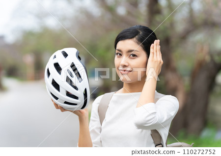 Young woman wearing a white cycling helmet Young woman wearing a white cycling helmet 110272752