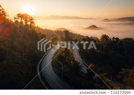Aerial view of road in mountain valley at sunrise Aerial view of road in mountain valley at sunrise 110273090