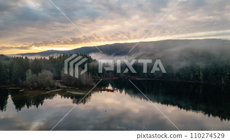 Valley by Lake, Mountains and Green Trees covered in fog. Canadian Nature Aerial Background 110274529