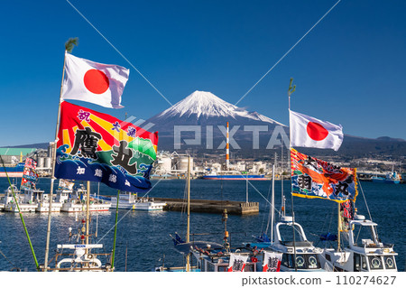 [Shizuoka Prefecture] Mt. Fuji, a fishing boat raising a big catch flag, Tagonoura Port welcoming the new year 110274627