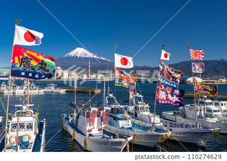 [Shizuoka Prefecture] Mt. Fuji, a fishing boat raising a big catch flag, Tagonoura Port welcoming the new year 110274629