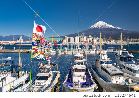 [Shizuoka Prefecture] Mt. Fuji, a fishing boat raising a big catch flag, Tagonoura Port welcoming the new year 110274641