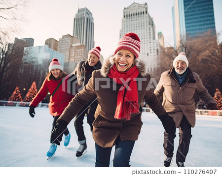 A group of cheerful senior multi-ethnic friends men and women enjoy ice skating in a city park rink with skyscrapers in the background 110276407