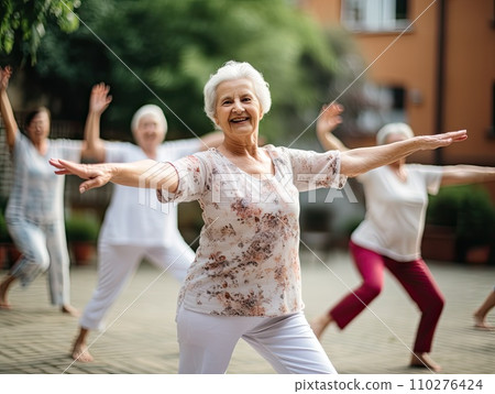 Joyful senior women engage in a tai chi yoga class outdoors, with a focus on the beaming lady in floral in the foreground Joyful senior women engage in a tai chi yoga class outdoors, with a focus on the beaming lady in floral in the foreground 110276424