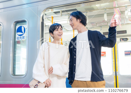 A young couple going on a train trip. Photography provided by Keio Electric Railway Co., Ltd. 110276679