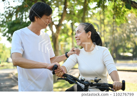 Shot of happy retired couple riding bicycles at summer park. Healthy lifestyle concept. 110276799