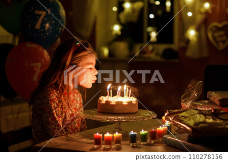 Happy little girl celebrating birthday. Cute smiling child with homemade princess cake, indoor. Happy healthy preschool kid blowing seven candles on cake 110278156
