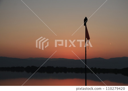 Sunset over the Kiso River and birds perched on the flag Sunset over the Kiso River and birds perched on the flag 110279420