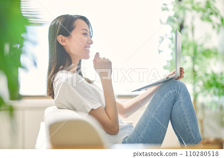 一個年輕女子在客廳裡看電腦 110280518