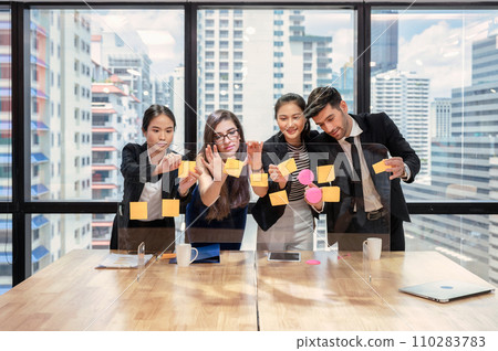Multi ethnic business team brainstorming with paste color post it note on board in modern office Multi ethnic business team brainstorming with paste color post it note on board in modern office 110283783