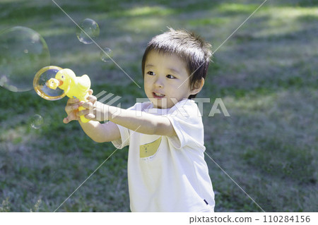 Boy playing with soap bubbles in the park 110284156