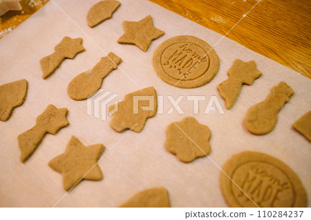 Process of making heart-shaped gingerbread for Christmas and New Year. Traditional festive food making, family culinary.  110284237