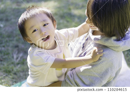 A smiling boy being held by his mother 110284615