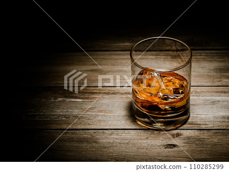Classic whiskey glass with ice cubes on wooden background.Top view. 110285299