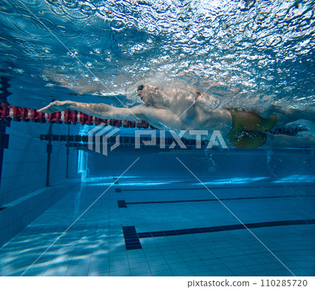 Professional swimming athlete in motion, training, practicing techniques, swimming in pool Professional swimming athlete in motion, training, practicing techniques, swimming in pool 110285720