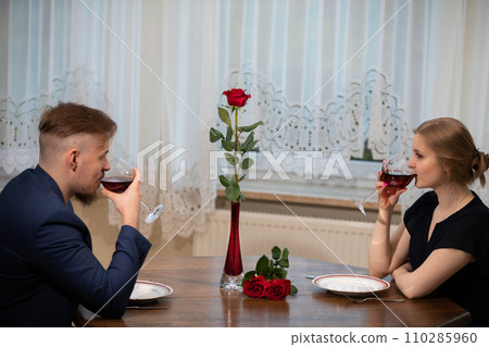 People drink red wine at the table after a family dinner. 110285960