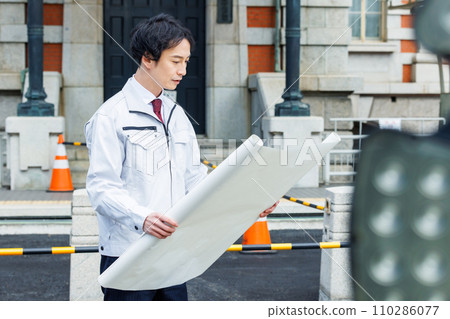 Site supervisor checking drawings at the construction site 110286077