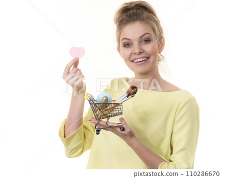 Woman holding shopping cart with make up brushes 110286670