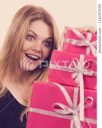 Surprised girl with pink gift boxes 110287038