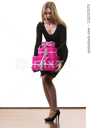 Girl carrying many pink gift boxes 110287070