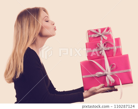 Girl holding stack of pink gift boxes Girl holding stack of pink gift boxes 110287124