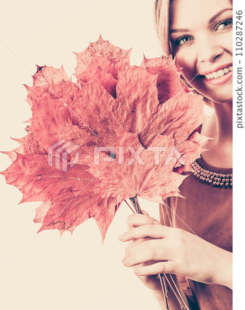 Woman holding orange autumn leaf Woman holding orange autumn leaf 110287246