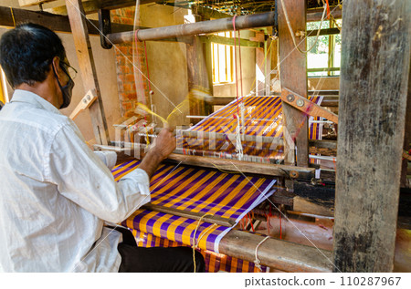 Cotton weaving on a traditional wooden handloom Cotton weaving on a traditional wooden handloom 110287967