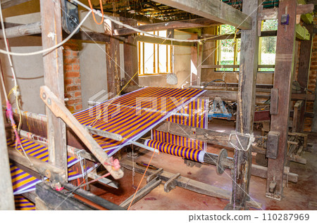 Cotton weaving on a traditional wooden handloom 110287969