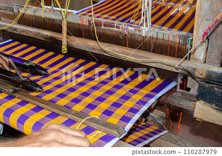 Cotton weaving on a traditional wooden handloom Cotton weaving on a traditional wooden handloom 110287979