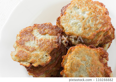 potatoes fritters with a golden crust in a white ceramic plate closeup 110288882