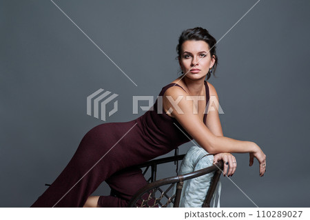 Fashionable young woman posing on dark gray studio background 110289027