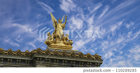 Golden statue of Liberty on the roof of the Opera Garnier (Garnier Palace)  against the sky with clouds. Sculpted by Charles Gumery in 1869. Paris, France. UNESCO World Heritage Site 110289285