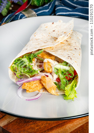 Wholegrain tortilla wraps with vegetables and chicken on a plate. Wholegrain tortilla wraps with vegetables and chicken on a plate. 110291570