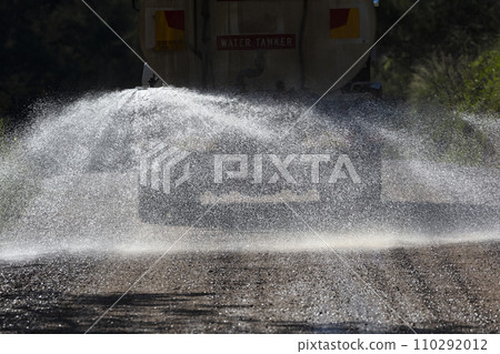 A water tanker spraying water on a dirt road in regional Australia 110292012