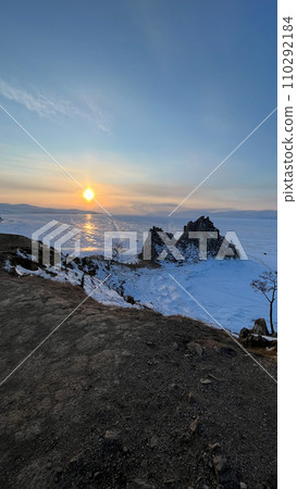 Sunset on the beach of Lake Baikal with rocks in front snow shore Baikal winter Sunset on the beach of Lake Baikal with rocks in front snow shore Baikal winter 110292184