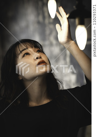 A woman holding her hand over retro lighting 110293371