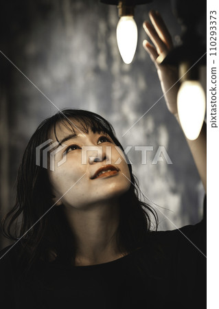 A woman holding her hand over retro lighting 110293373