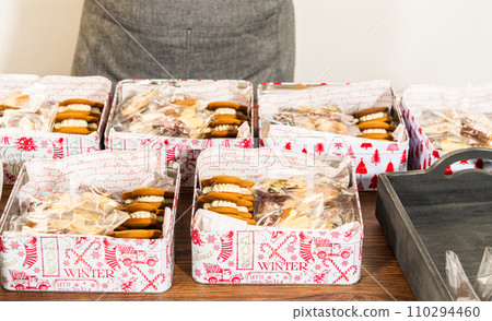 Lovingly homemade gingerbread and sugar cookies, half-dipped in rich chocolate, nestled in decorative Christmas tin boxes perfect for seasonal gifting. 110294460