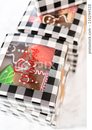 Packaging a homemade variety of fudge and gingerbread cookies for Christmas food gifts into paper boxes. Packaging a homemade variety of fudge and gingerbread cookies for Christmas food gifts into paper boxes. 110294528