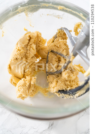 Mixing ingredients in kitchen electric mixer to bake panda-shaped shortbread cookies with chocolate icing. Mixing ingredients in kitchen electric mixer to bake panda-shaped shortbread cookies with chocolate icing. 110294538