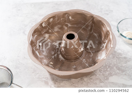 Greasing metal bundt cake pan to bake carrot bundt cake with cream cheese frosting. 110294562