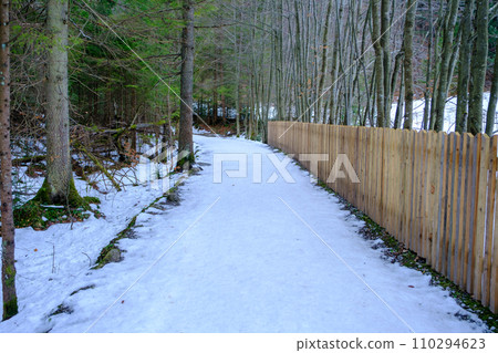 a long wooden fence separates the property area. the winter tourism trail goes along the fenced off property a long wooden fence separates the property area. the winter tourism trail goes along the fenced off property 110294623