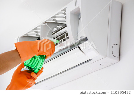 Asian man cleaning air conditioner with spray bottle Asian man cleaning air conditioner with spray bottle 110295452